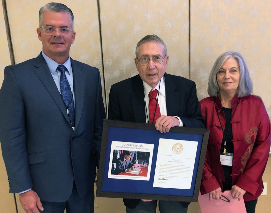 Howard Marcus awarded plaque for twenty years of service and success.